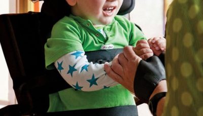 Kind in Reha Sitzsystem wird von Fachkraft betreut als Beispiel für Kinderhilfsmittel bei Saniplus Baunatal