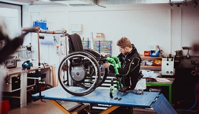 Techniker arbeitet an individuellem Rollstuhlumbau in Werkstatt von Saniplus Baunatal