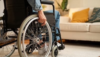 Person im Rollstuhl im Wohnraum als Beispiel für barrierefreies Wohnen bei Saniplus Baunatal